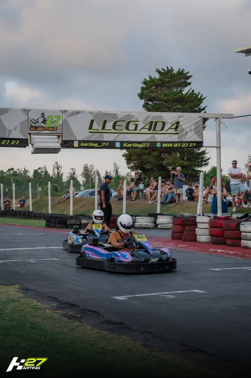 Karts cruzando la línea de llegada con espectadores en Karting 27