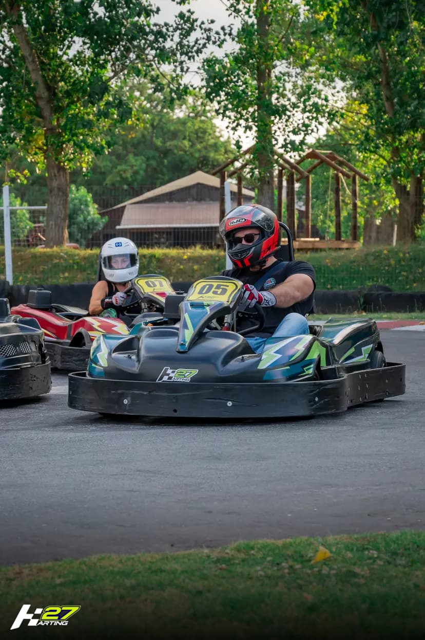 Dos pilotos compitiendo codo a codo en la pista de Karting 27